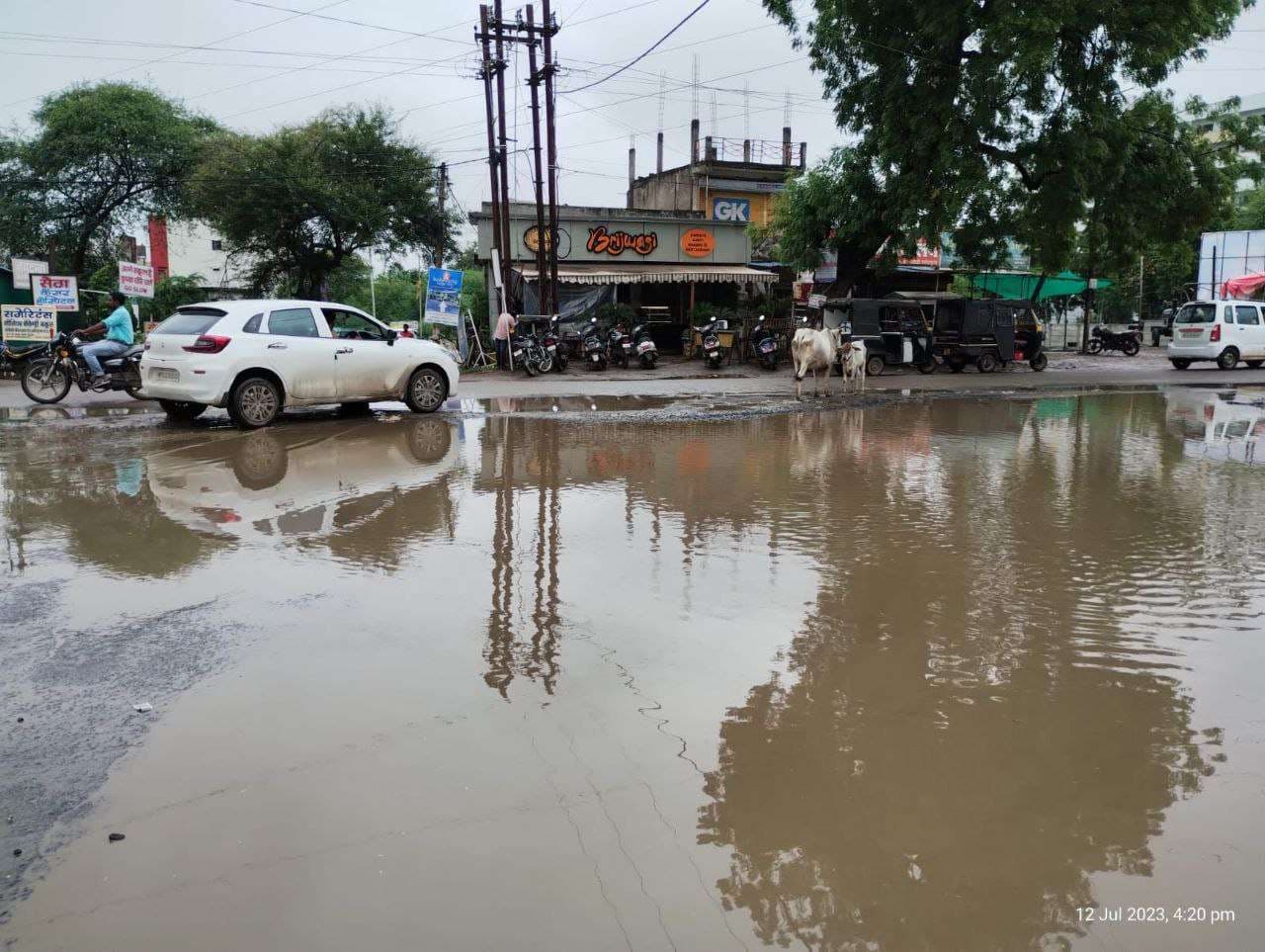 नर्मदा घाट पर जमा हुई मिट्टी सड़कों के गड्ढों में भराया बारिश का पानी