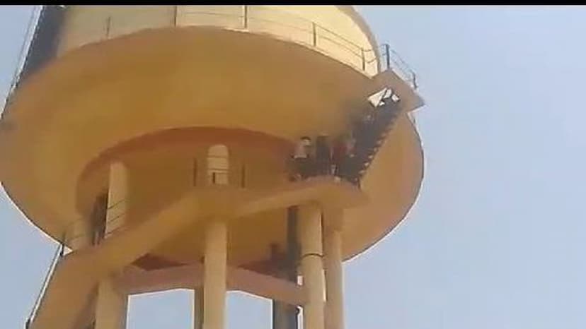 Villagers suffering from drinking water crisis climb on water tank