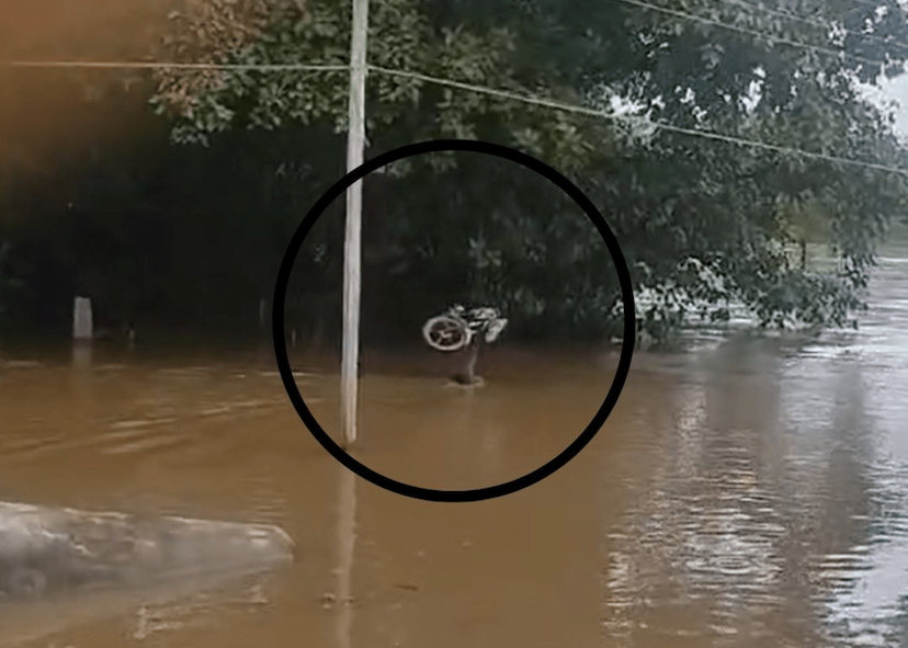 Young man crossed the drain by lifting his bike on his head in