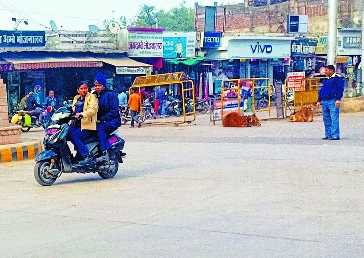 बारां. चारमूर्ति चौराहे से बिना हेलमेट पहने गुजरती महिला कांस्टेबल, दूर खड़ा यातयात पुलिसकर्मी मानो जैसे इससे पूरी तरह से अनजान बना हुआ है।   	पत्रिका